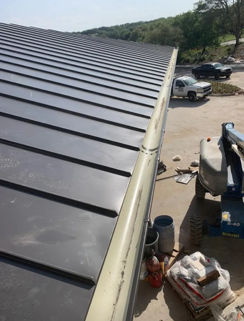 Standing seam panel and gutter detail on a metal roofing jobsite in Killeen